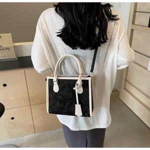 Artistic black and white textured tote bag shown on model in minimalist interior setting