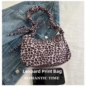 Leopard print underarm bag detail with pleated strap shown next to a phone for size
