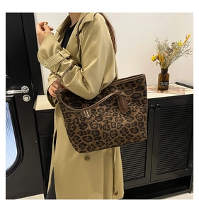 Close-up of stylish leopard print tote bag with premium leather straps on a model