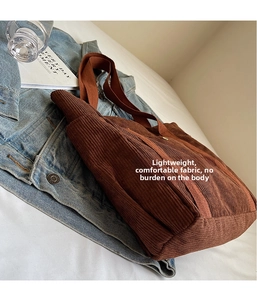 Detail of brown corduroy tote bag showing thick rib texture and reinforced stitching