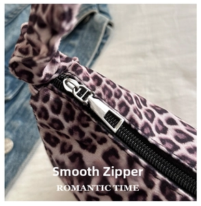 Detail of silver metal zipper on leopard print shoulder bag with plush fabric texture