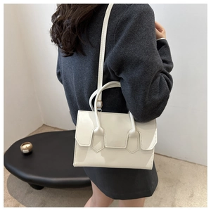Minimalist pearl white crossbody bag shown with adjustable shoulder strap and smooth texture