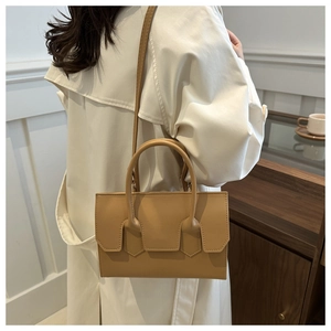 Detailed view of camel leather shoulder bag with geometric flap and slim strap