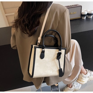 Close-up of elegant tote bag with marble pattern and black leather trim details