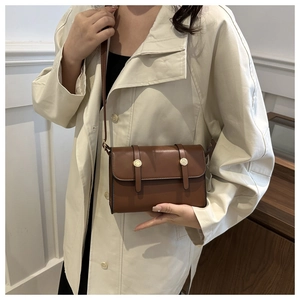 Brown vintage faux leather crossbody bag with decorative straps and gold metal buckles