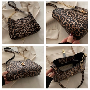 Detail view of leopard print shoulder bag featuring gold chain and secure metal twist lock