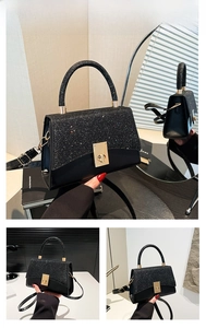 Detail view of black square handbag with glitter flap, metal turn-lock and top handle