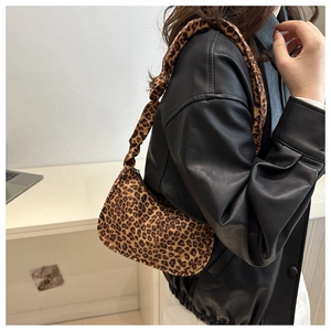 Close-up of leopard print tote bag with crescent shape worn by model in leather jacket