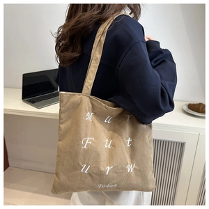 Détail du sac cabas en velours côtelé kaki avec broderie de lettres blanches