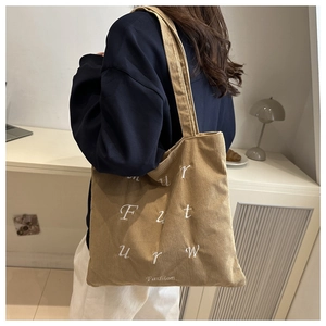 Detail of khaki corduroy tote bag featuring Future Fashion white letter embroidery