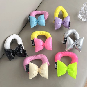 Colorful puffy bow hair ties with shiny padded texture and black logo labels