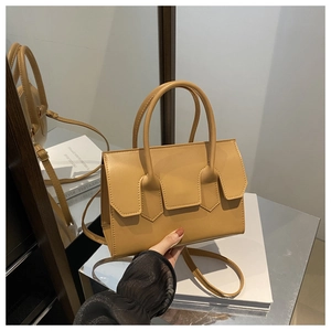 Vue détaillée du sac à bandoulière marron clair avec doubles poignées et boucle géométrique