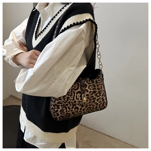 Détail du sac léopard avec boucle en métal doré et bandoulière en chaîne sur mannequin