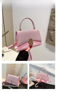 Detailed close-up of a pink rhinestone crossbody bag with metal twist lock and leather trim