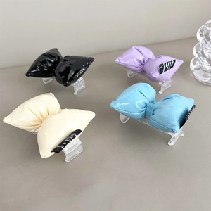 Close-up of padded PU leather bow hair clips in black, lilac, cream and light blue colors