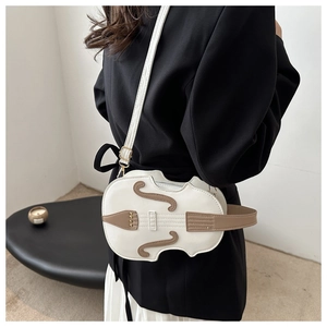 Creative violin-shaped crossbody bag on a model wearing a black blazer for a chic look