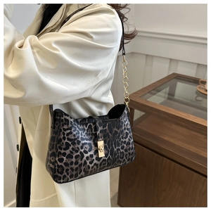 Détail d'un sac sous le bras à motif léopard avec fermoir doré vintage et bandoulière
