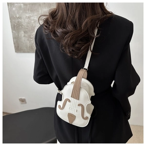 Close-up of violin-shaped crossbody bag with white leather and brown stitch detail