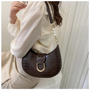 Detail of dark brown faux crocodile leather bag with pearl shoulder strap and U-shaped buckle