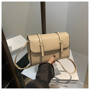 Détail du sac bandoulière en cuir beige avec rabat et boucle en métal doré