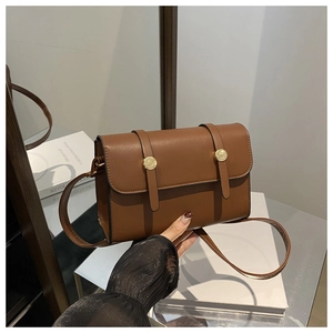 Détails du sac bandoulière en cuir marron avec boucles dorées et finitions de haute qualité