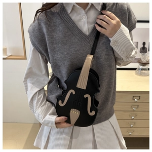Detailed side view of violin-shaped crossbody bag in matte black and brown leather
