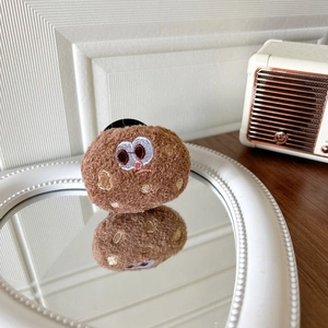 Detailed close-up of brown plush chocolate cookie phone socket with cute embroidery