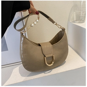 Detail of khaki crocodile texture underarm bag with gold D-buckle and pearl strap