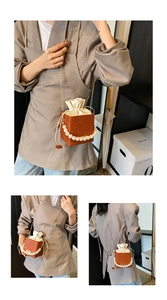 Detail of a brown bucket bag with pearl handle, drawstring pouch, and gold chain strap