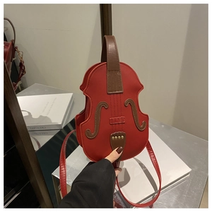 Detail of creative violin-shaped red shoulder bag with realistic F-holes and brown handle