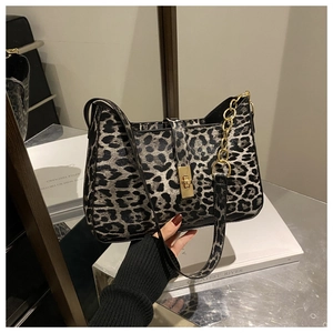 Détail du sac à bandoulière léopard avec boucle dorée et décorations de chaîne