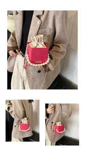 Detail of rose pink box bucket bag featuring lace embroidery and oversized pearl handle