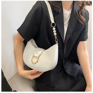 Detail of white crocodile pattern crescent bag with pearls and golden U-shaped hardware