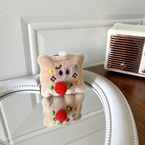 Detail of plush cookie phone grip with cute embroidery on a vintage mirror surface