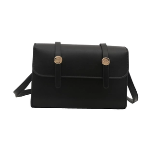 Petit sac bandoulière rectangulaire noir minimaliste avec boucles dorées sur fond blanc