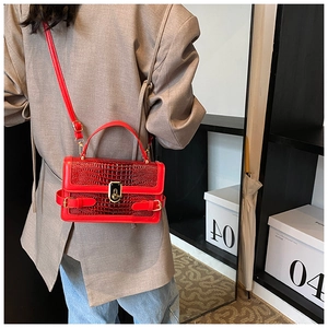 Detail of red crocodile pattern PU leather crossbody bag with gold-tone twist lock