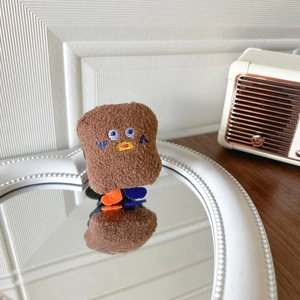 Macro detail of plush chocolate cookie phone grip with fine embroidery on a mirror