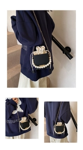 Detail of mini bucket bag featuring pearl handle and contrast drawstring closure