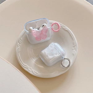 Clear AirPods case with 3D butterfly relief and round carabiner on aesthetic dish