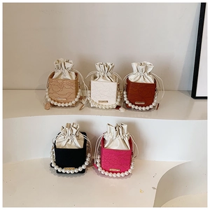 Detail of lace floral crossbody bags with pearl handles and drawstring silk lining