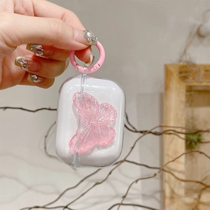 Clear AirPods case with a 3D pink butterfly and matching hook, shown in hand