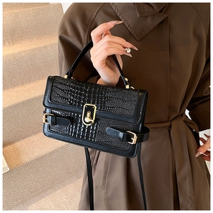 Detail of black crocodile texture PU leather crossbody bag with gold buckle hardware