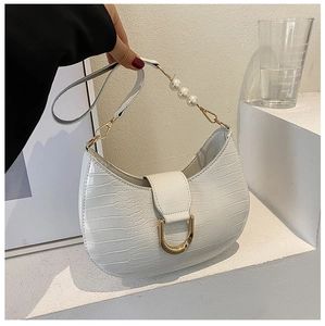 Detail of white crocodile embossed texture and pearl strap on the half moon shoulder bag