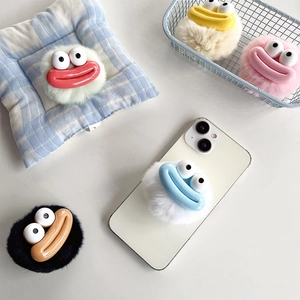 Cute plush cartoon phone socket holder with large eyes and colorful lips on a white smartphone