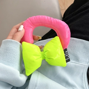 Detail of neon pink puffer wrist strap with green bow for mobile phone cases