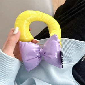 Detail of vibrant yellow and purple oversized bow phone grip with glossy texture