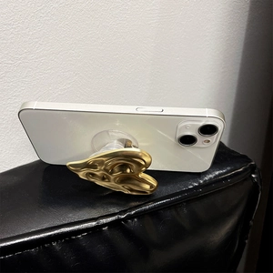 Support de téléphone cœur en métal liquide doré sur smartphone blanc brillant