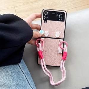 Pink leather Galaxy Z Flip 5 case with braided crossbody strap and cute ear design