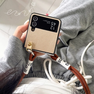 Detail of champagne gold textured flip case with brown woven lanyard for Z Flip