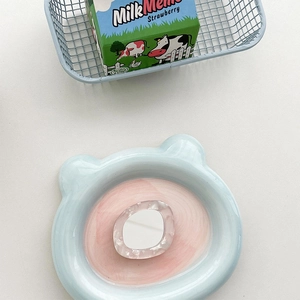 Detail of white marble textured acrylic ring accessory on a cute blue ceramic bear tray
